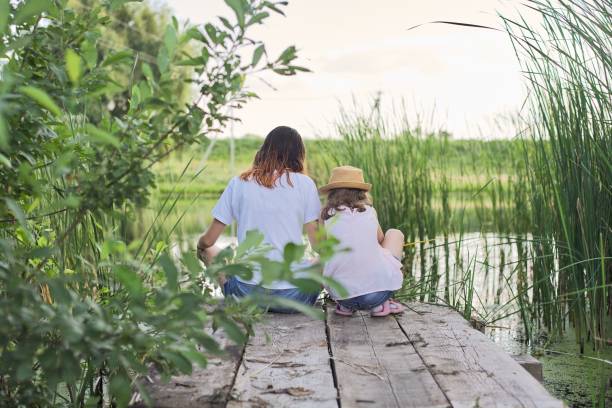 istock Children resting near the water on sunny summer day, back view 1210323251