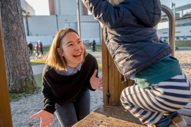 Millennial Mother and Her Son of Two Playing in a Playground, Europe Mother assisting her son while he climbs outdoors, Slovenia, Europe. Nikon D850. nova gorica stock pictures, royalty-free photos & images