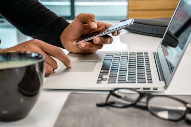 zbliżenie zdjęcia mężczyzn za pomocą telefonu i laptopa - digital press zdjęcia i obrazy z banku zdjęć