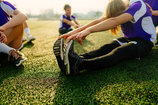 Photo of teenage girls stretching before the soccer match