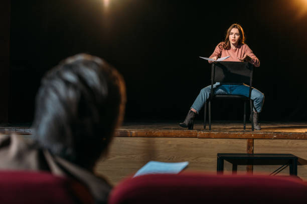 selective focus of stage director and actress performing role with screenplay in theater selective focus of stage director and actress performing role with screenplay in theater actress audition stock pictures, royalty-free photos & images