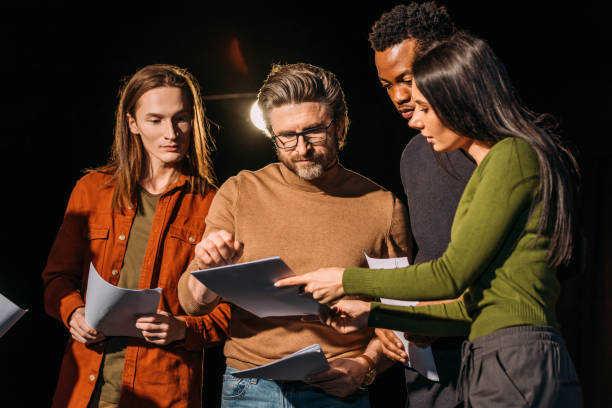 istock theater director, multicultural actors and actress rehearsing with scripts on stage 1210331680
