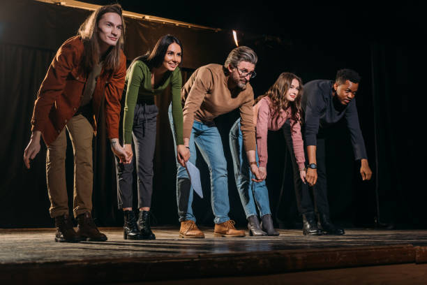 happy actors and actresses bowing on stage happy actors and actresses bowing on stage curtain call stock pictures, royalty-free photos & images