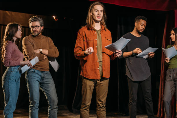 istock multicultural actors and actresses rehearsing with scripts on stage in theatre 1210331692