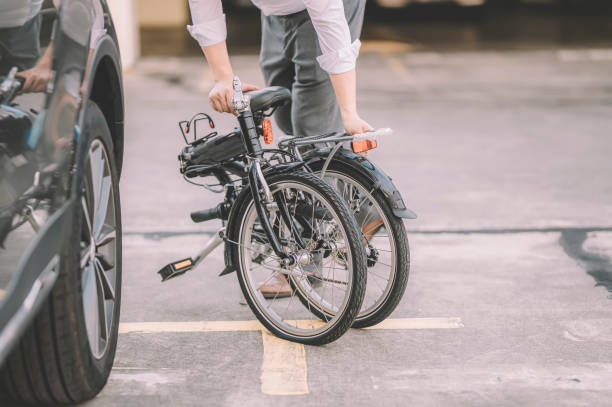 an asian chinese male white collar worker getting ready to work with his folding bicycle as transport commuting