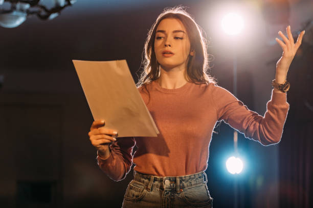 young actress reading scenario on stage in theatre young actress reading scenario on stage in theatre stage theater stock pictures, royalty-free photos & images