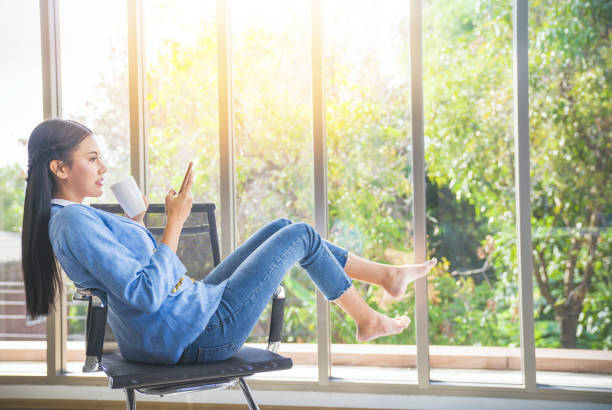 istock Asian  young teenage on vacation relaxing using digital tablet and smart phone for doing homework at home and relax with online game and text message on social network 1210333321