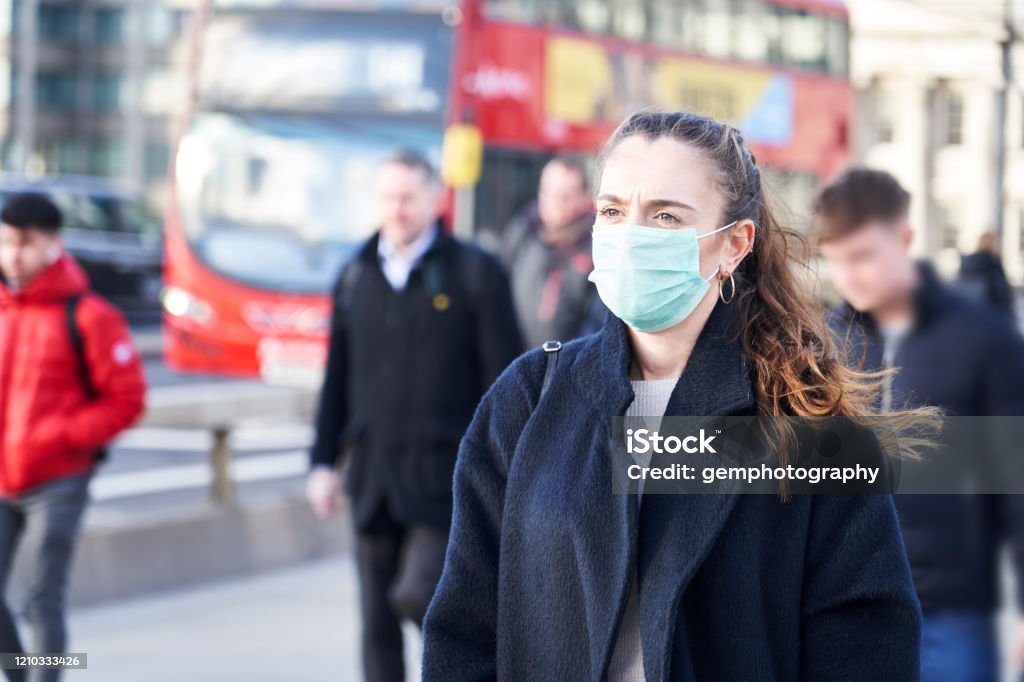 Young woman wearing face mask while walking in the streets of London Protective Face Mask Stock Photo