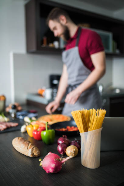 istock Cooker man chopping carrot on kitchen board. 1210334739