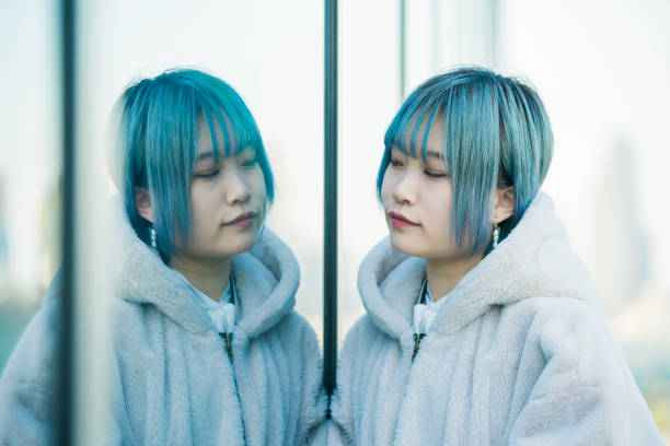 istock young woman and her reflection 1210336758