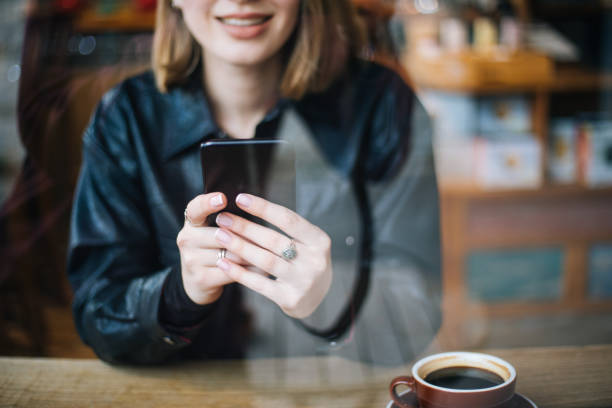 istock Beautiful woman using smartphone at cafe 1210337874