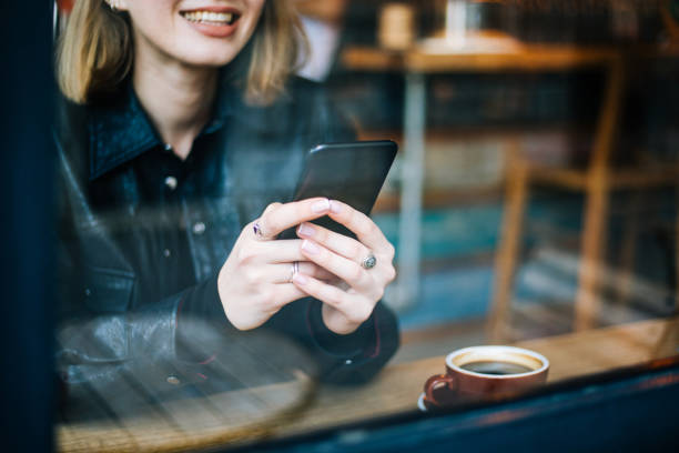 istock Beautiful woman using smartphone at cafe 1210338022
