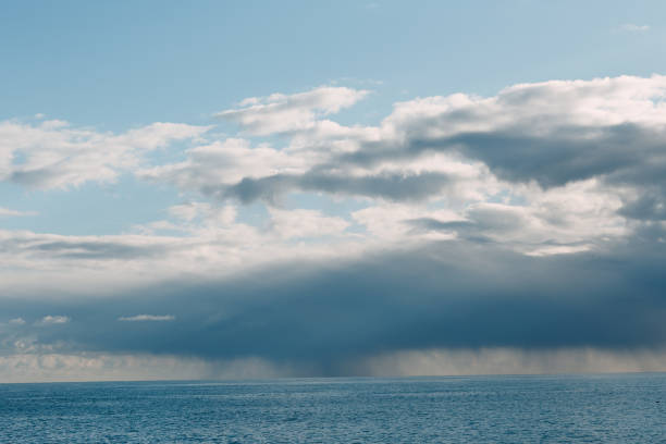 istock Thundercloud with rain on the sea horizon 1210338220