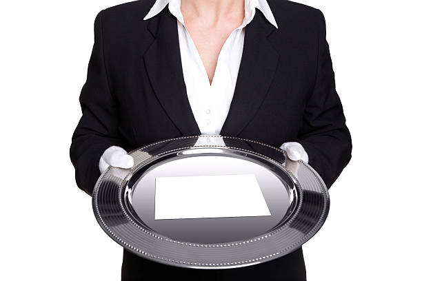 femmina maggiordomo tenendo un vassoio d'argento isolato su bianco. - serving tray silver plate foto e immagini stock