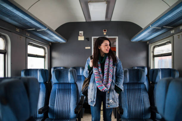 istock Woman with a backpack walking in wagon in the train 1210342786