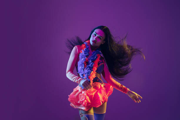 istock Attractive hawaiian brunette model on purple studio background in neon light 1210342793