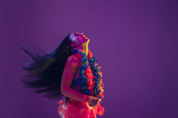 istock Attractive hawaiian brunette model on purple studio background in neon light 1210342805