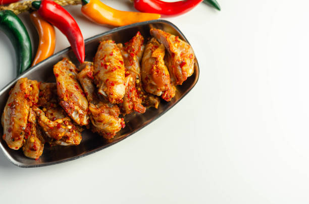 Raw and fresh chicken wings in a siriracha marinade, ready for grilling