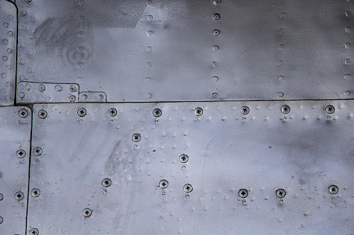 Aircraft skin close up. Rivets on gray metal. Aluminum texture