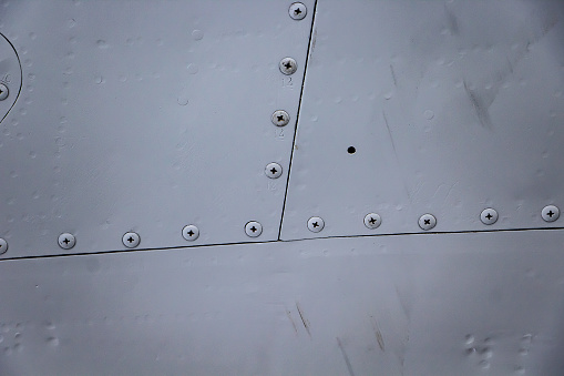 Aircraft skin close up. Rivets on gray metal. Background for design.