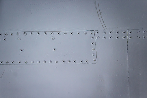 Aircraft skin close up. Rivets on gray metal. Background for design.