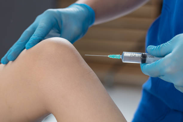 The doctor puts an injection into the knee joint of the patient. Injection in the knee The doctor puts an injection into the knee joint of the patient. medical injection photos stock pictures, royalty-free photos & images