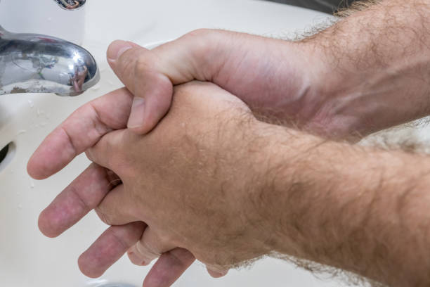 istock Man washing hands in basin close-up 1210348029