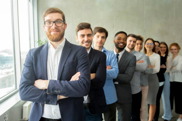 istock Happy business team headed with boss standing in row 1210349830