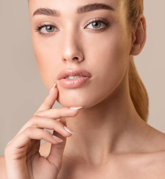 istock Attractive Woman Touching Lips Posing On Beige Studio Background, Cropped 1210351062