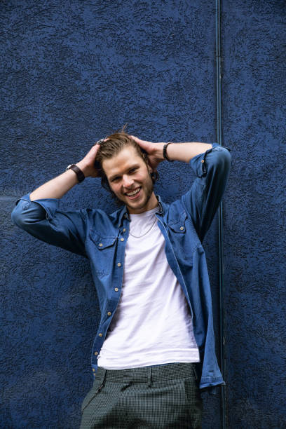istock Young man portrait against a deep blue wall 1210352702