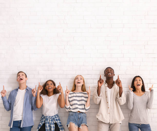 istock Group of multiracial friends pointing up at copy space 1210353266