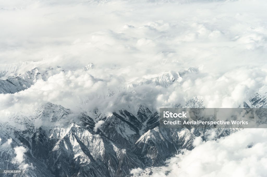 Aerial View of Snow capped Mountains against Sky Many of the world's highest mountains are located in Pakistan. Mountain Stock Photo