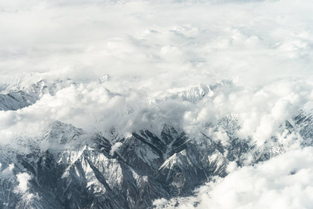 Aerial View of Snow capped Mountains against Sky Many of the world's highest mountains are located in Pakistan. k2 mountain panorama stock pictures, royalty-free photos & images