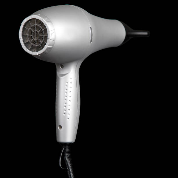 Hair dryer in a hair salon on a wooden table. Hairdressing accessories for hair care. Dark background.
