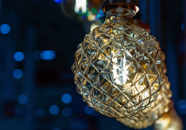 istock Round light bulb with dark faceted glass on a blue background. 1210360823
