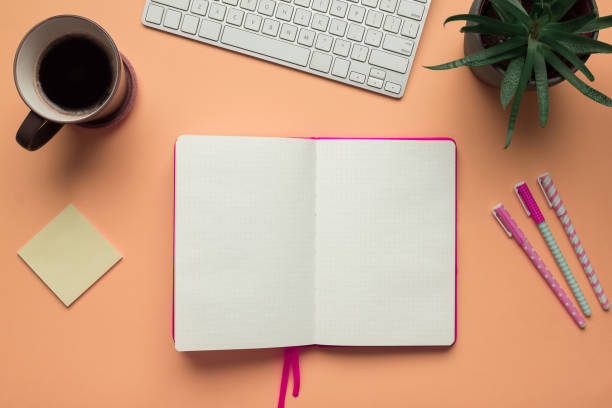 Stock photo of an open notebook page in an office desk table Stock photo of a blank open notebook page in the middle of office desk table bullet journal photos stock pictures, royalty-free photos & images
