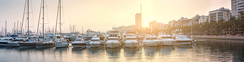 Breathtaking romantic summer panoramic view of boats and yachts in harbor in evening sunshine glow. Costa Blanca. Alicante, province of Valencia, Spain.