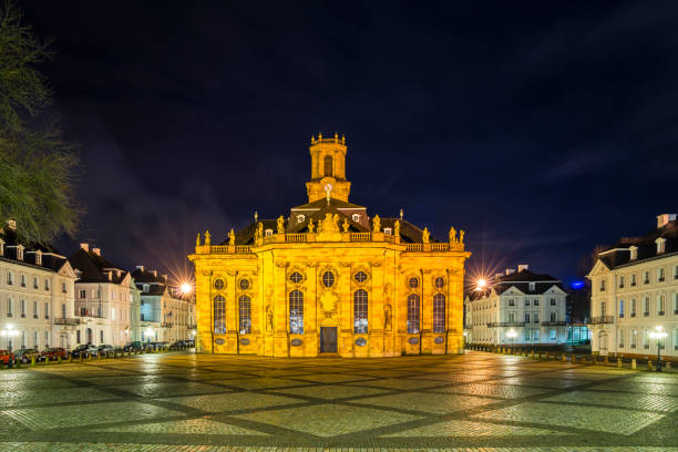 Germany, Famous ancient baroqhe style church ludwigskirche in downtown saarbruecken by night illuminated in magical atmosphere stock photo