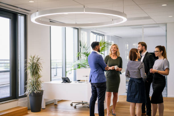istock Diverse group of business people conversing in office lobby 1210364366