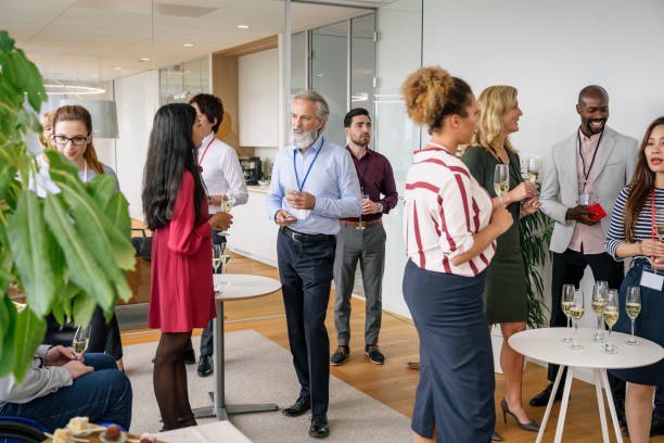 istock Business people socializing with champagne at office event 1210364400
