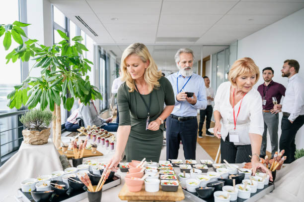 istock Businesswomen selecting savory food from party buffet 1210364418