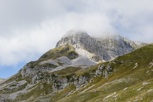 Gran Sasso, Italy - 31 July 2022 - The extreme trekking to Vetta Orientale of Corno Grande, 2902 meters in Abruzzo region, with Ferrata Ricci climbing way, glacier of Calderone and Rifugio Franchetti. Here in particular the peak with cross