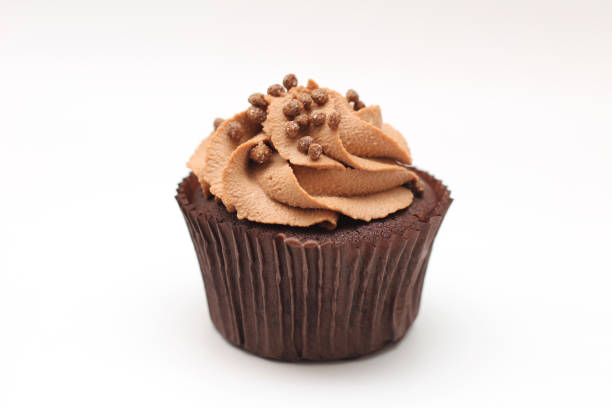 istock Isolated chocolate cupcake with cream top and crispy topping on a white background 1210366865