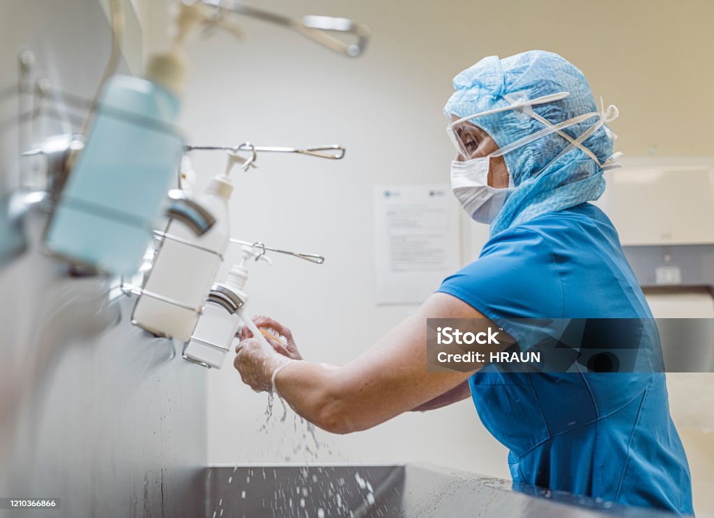 Enfermeira lavando as mãos para evitar o vírus Covid 19. - Foto de stock de Hospital royalty-free