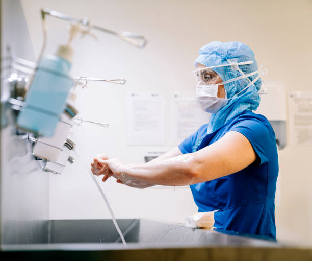 trabajador sanitario que realiza el saneamiento de las manos. - scrubbing up fotografías e imágenes de stock