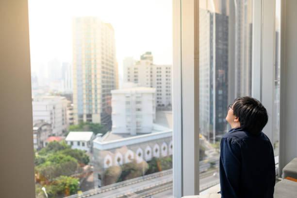 istock Asian man looking outside in office building 1210367540