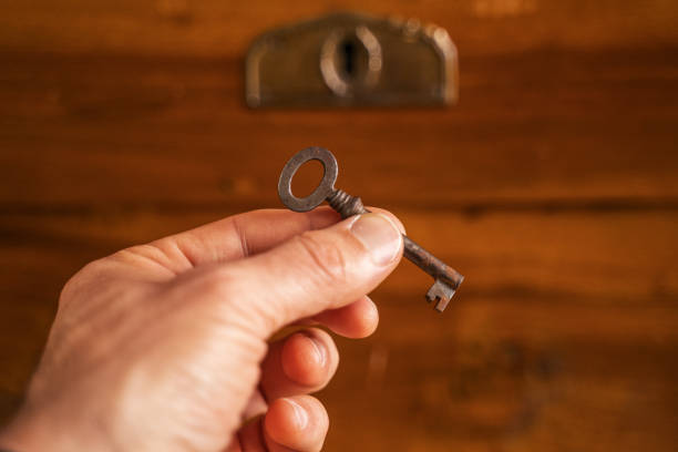 istock The key. Extreme close up of a hand unlocking an ancient coffer with a key. 1210369681