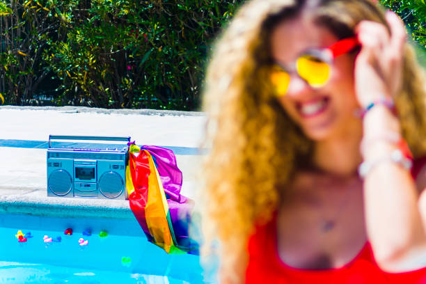 casete de radio y niña con gafas de sol junto a una piscina - gay pride flag audio fotografías e imágenes de stock