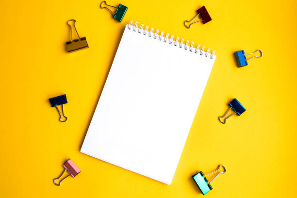 istock Mock up notebook and office accessories on yellow background with copy space, view from above 1210371071