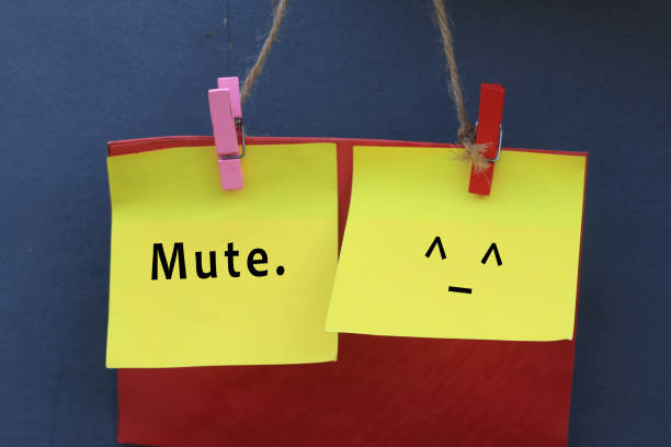 Single word - Mute and an emoticon sign. Inspirational note quote - Mute. With mute face emoticon on colorful origami paper hanging on wall with pin and rope. Silent single word creative idea concept. speak no evil stock pictures, royalty-free photos & images